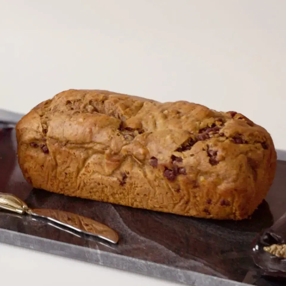 A loaf of spiced pumpkin banana bread on a serving tray