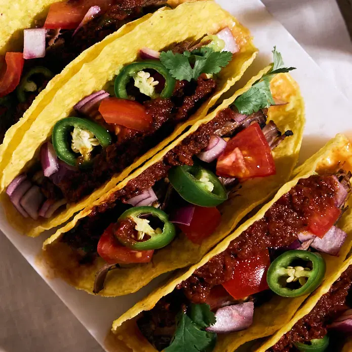 Beef tacos with cherry salsa, jalapeño slices, tomatoes, and cilantro