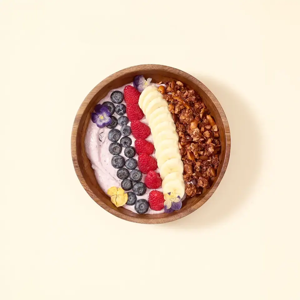 Coconut granola bowl with banana, berries, yogurt, and blueberry lavender spread