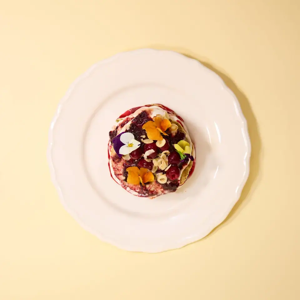Chia pancakes topped with cherry and rhubarb spread and edible flowers