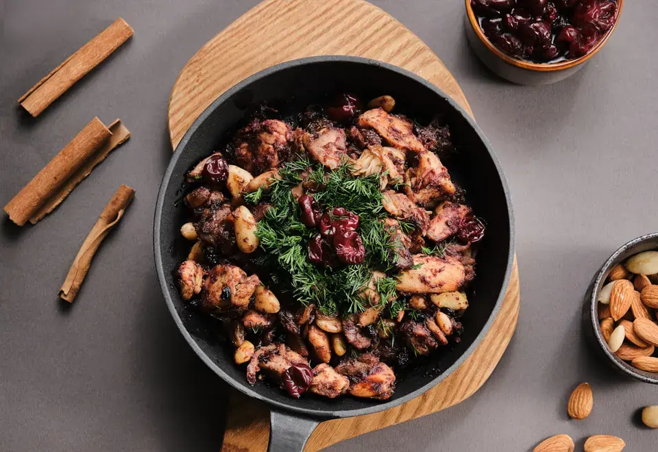 Chicken with cherry and rhubarb sauce, almonds, and dill in a skillet