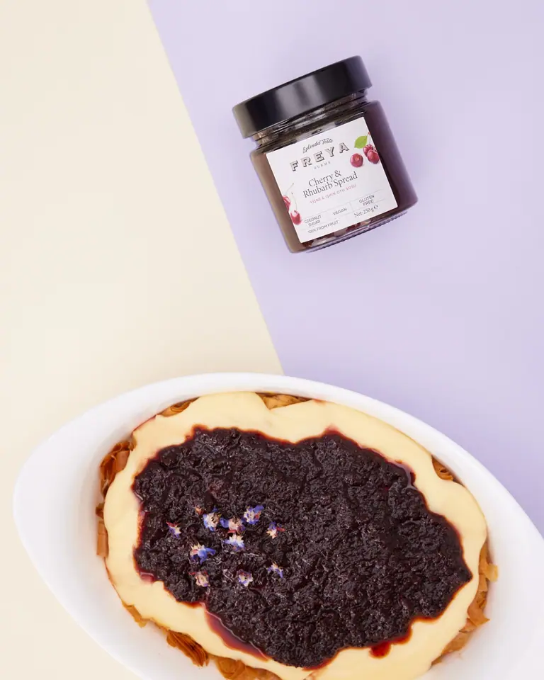 Cherry and rhubarb custard pastry with a dark fruit topping on an oval plate