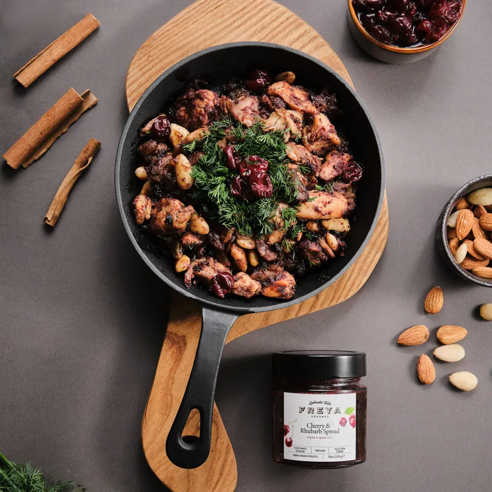 Cherry and rhubarb Mahmudiye chicken in a skillet garnished with herbs