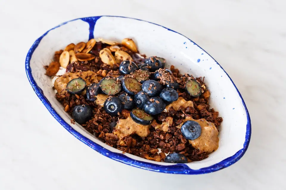 Chocolate granola bowl topped with blueberries and nuts