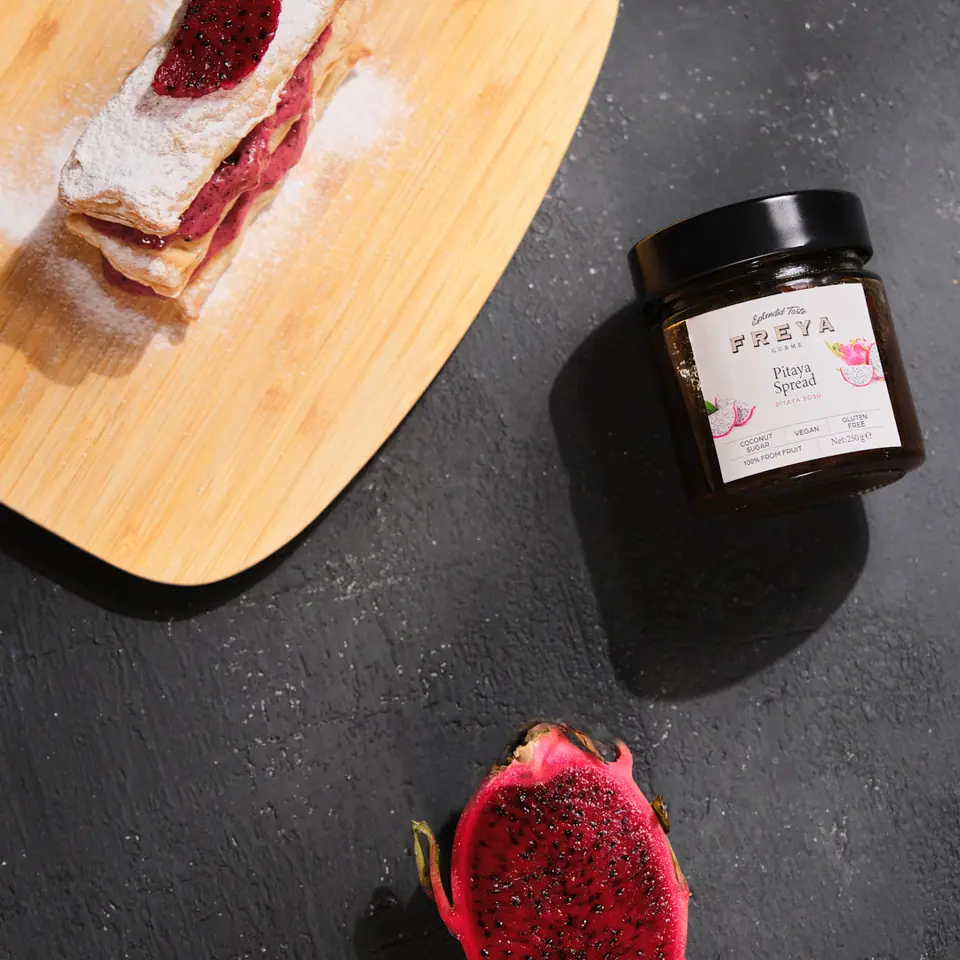 Dragon fruit cream pastry layers on a wooden serving board