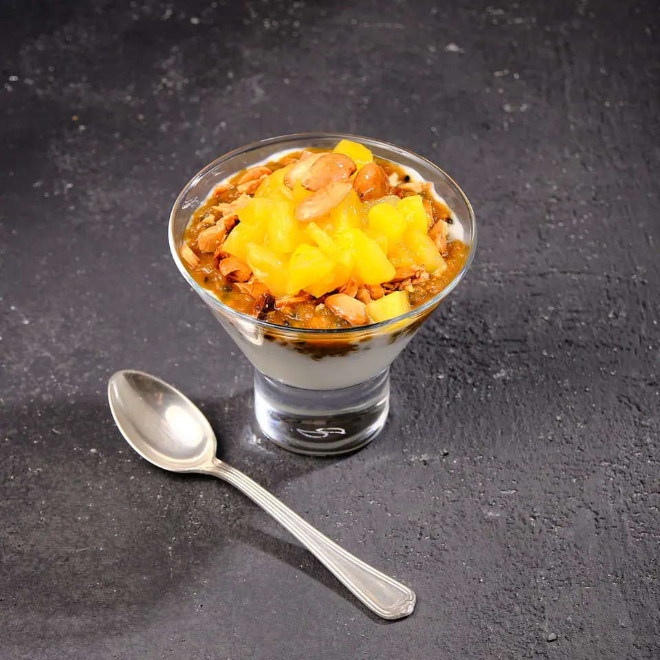 Mango and passion fruit fool layered in a glass with diced mango on top