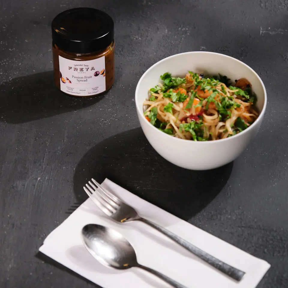 Shrimp pad Thai with vegetables and herbs in a white bowl