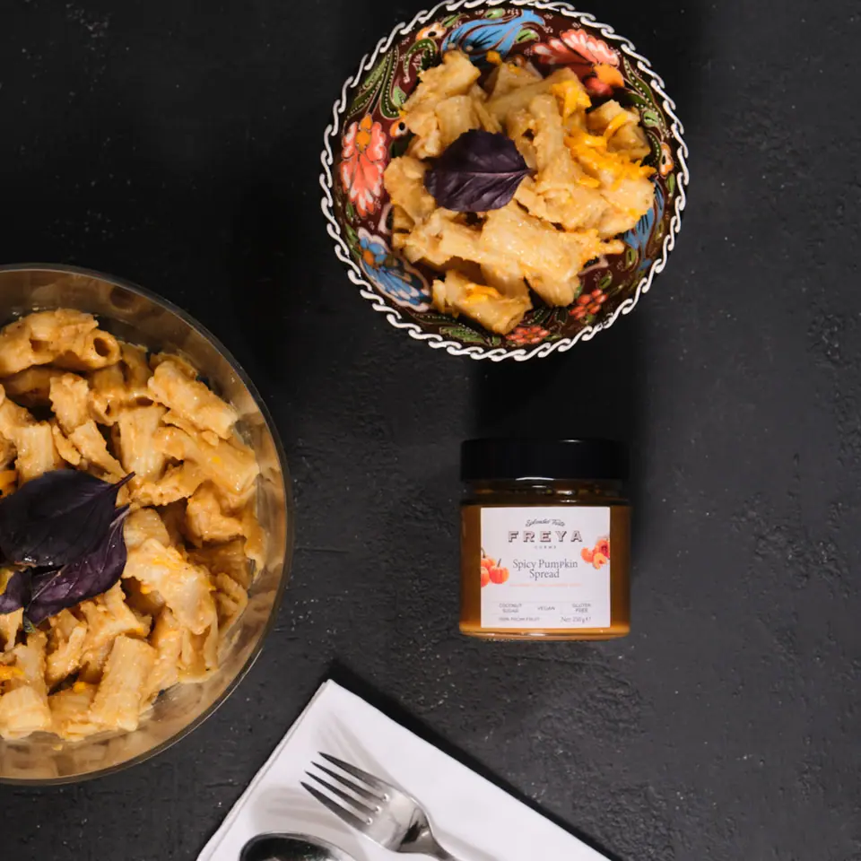 Spiced pumpkin macaroni and cheese in bowls on a dark tabletop