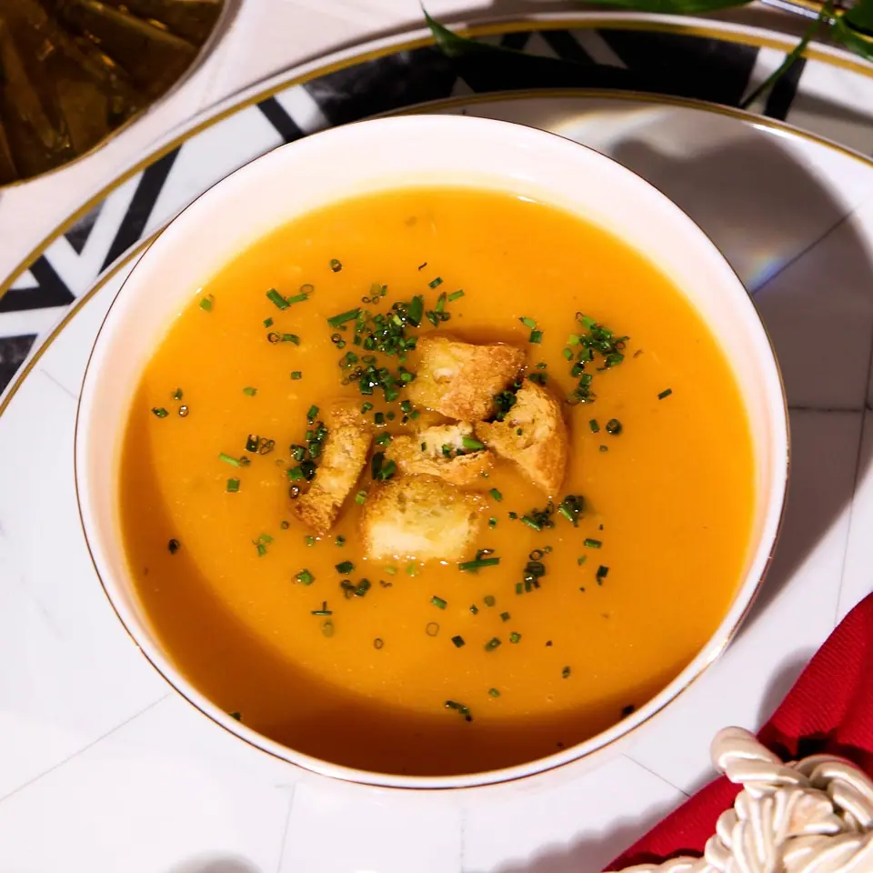 Orange spiced pumpkin soup topped with croutons and chopped herbs
