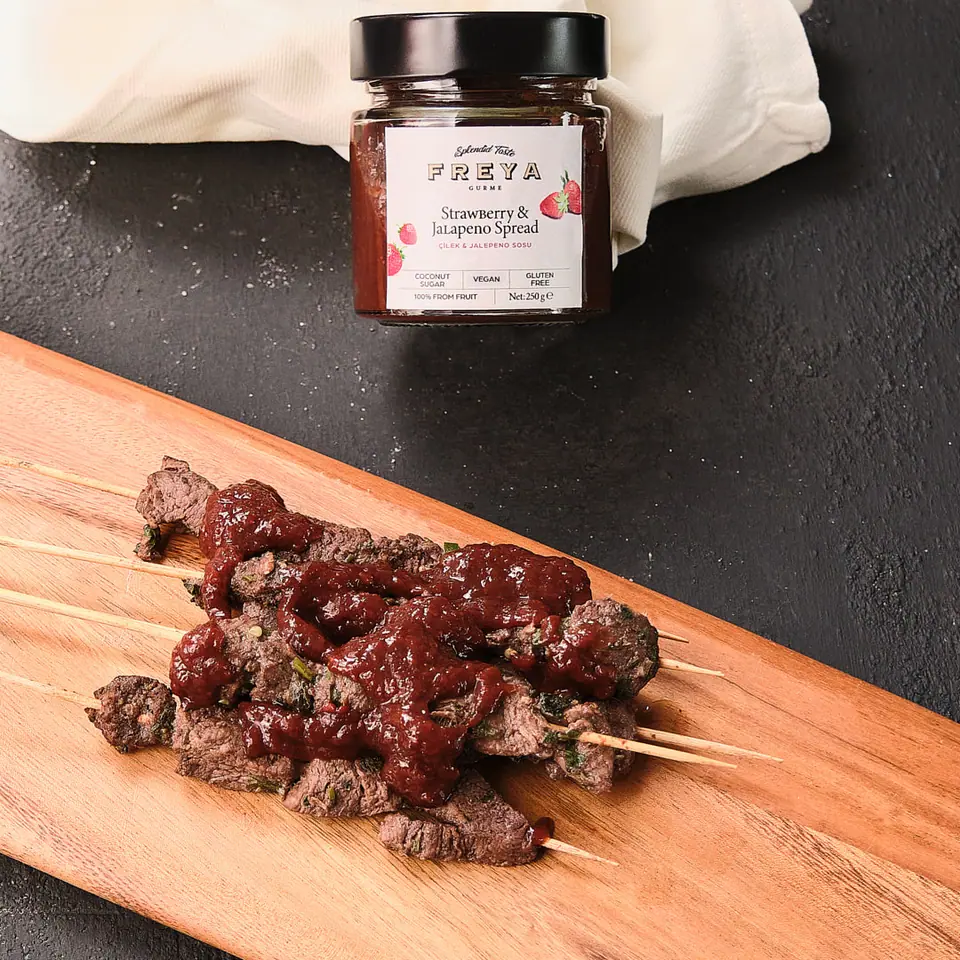 Strawberry jalapeño beef skewers on a wooden board